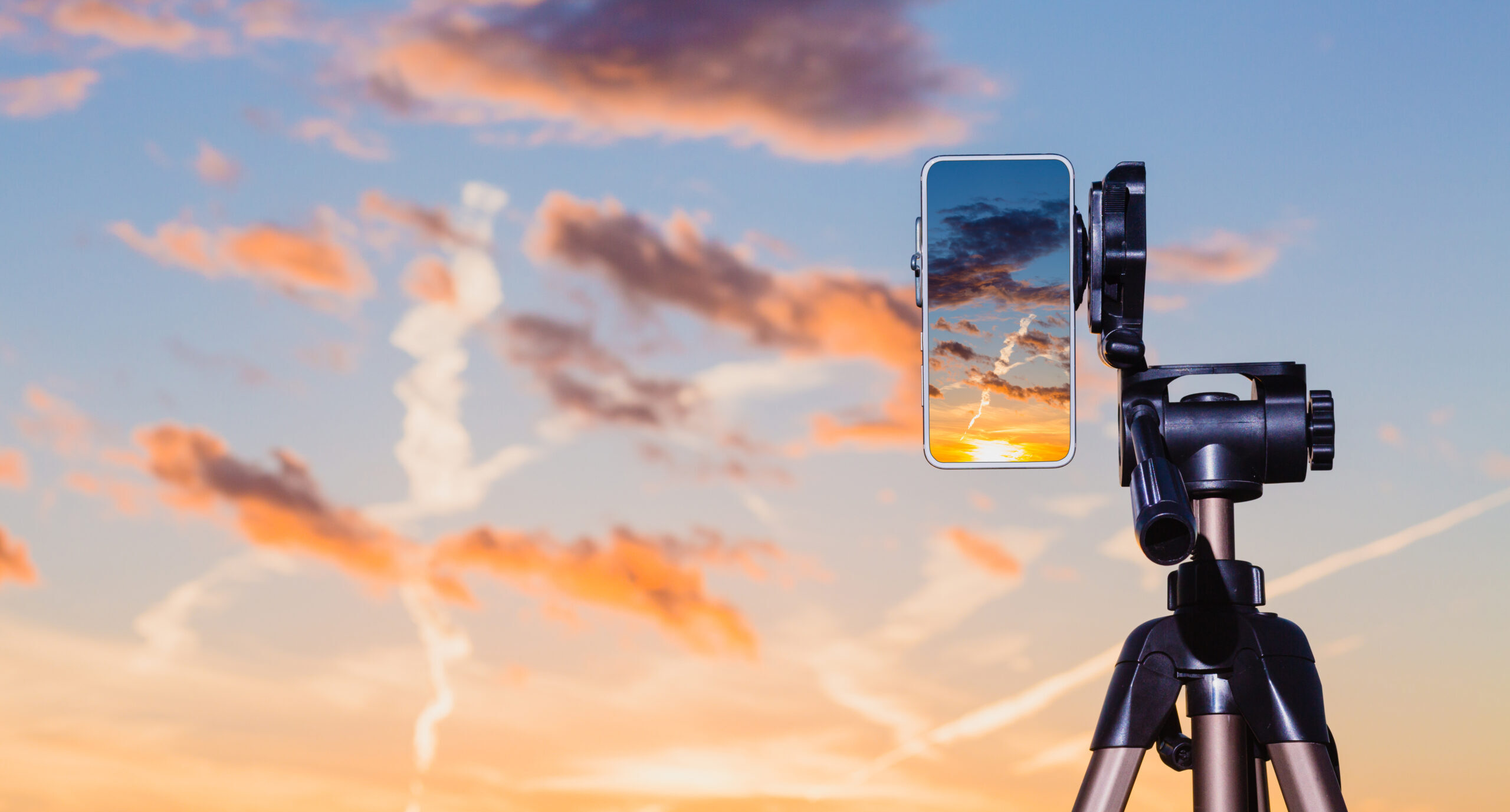 Smartphone On Tripod Capturing Image Of Sundown In Vertical Mode